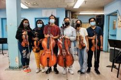 Photo of students standing with their string instruments