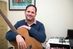 Image of Dr. Michael Viega holding a guitar