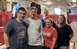 From left to right, Professor Stacy Gitlin, student Gianna Daginis, Professor Steve McCarthy, former Head Football Coach Rick Giancola and student Jason Naccarella take a break from prep for the students' trip to cover Sam Mills' induction into the Pro Football Hall of Fame. The documentary the students made from this trip has been nominated for an SVG College Sports Media Award.