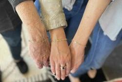 Image of 3 wrists wearing permanent bracelets