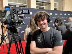 Aidan Ping, a junior Film and Television major, works on the 2024 Grammys' red carpet, where he recorded audio for handheld mic interviews. (Photo courtesy of Aidan Ping)