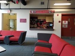 Two students sitting at the equipment checkout window