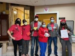 a group of people wearing masks stand side by side and pos for a photo