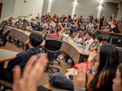 HSCI Participants with hands raised in classroom