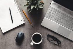 laptop and book, coffee on gray background, Top view of office desk on textured gray background