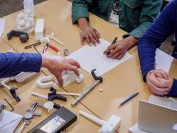 Top-down photo of a professor performing a demonstration of tools.